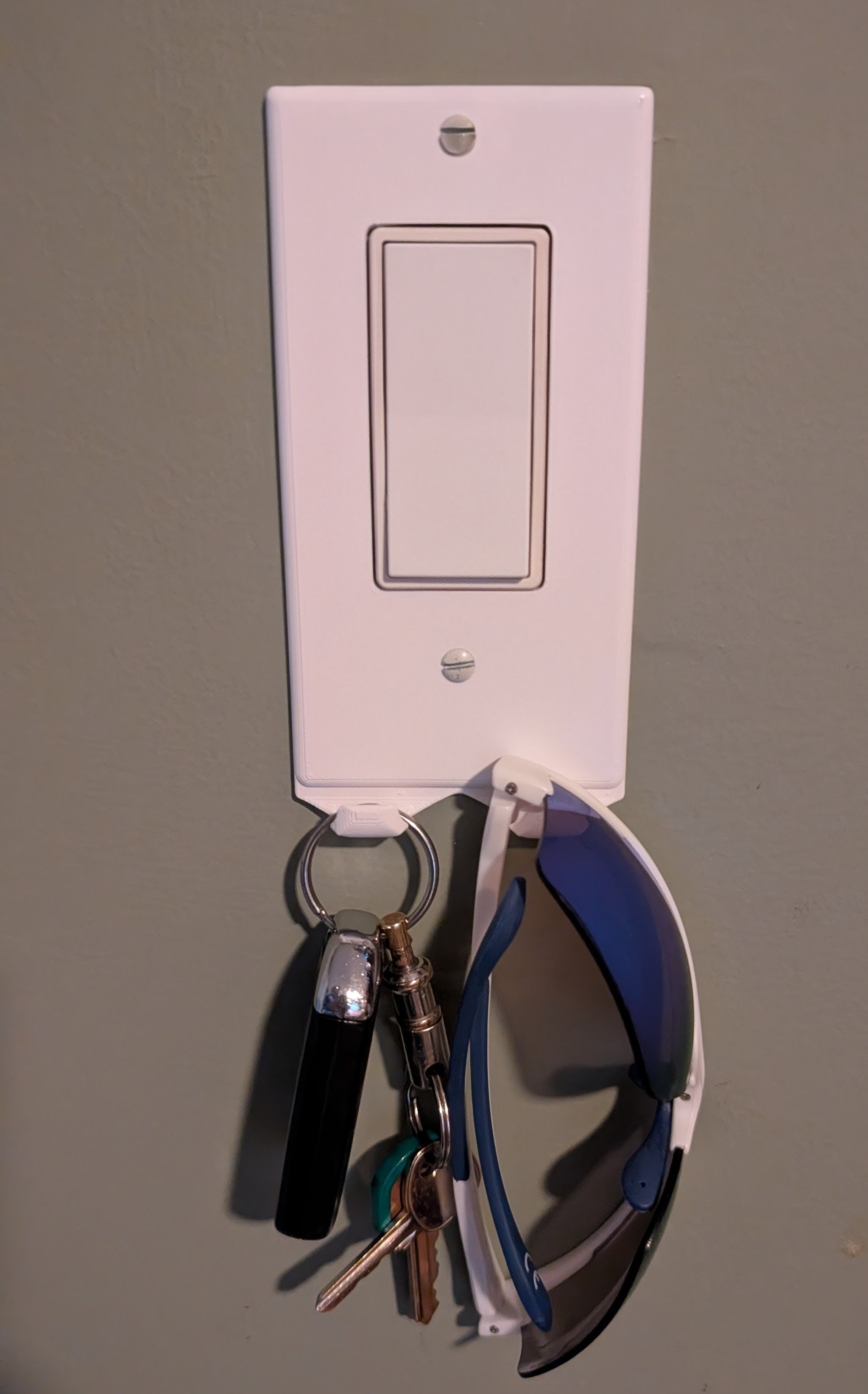 Decora light switch cover with integrated key hooks.